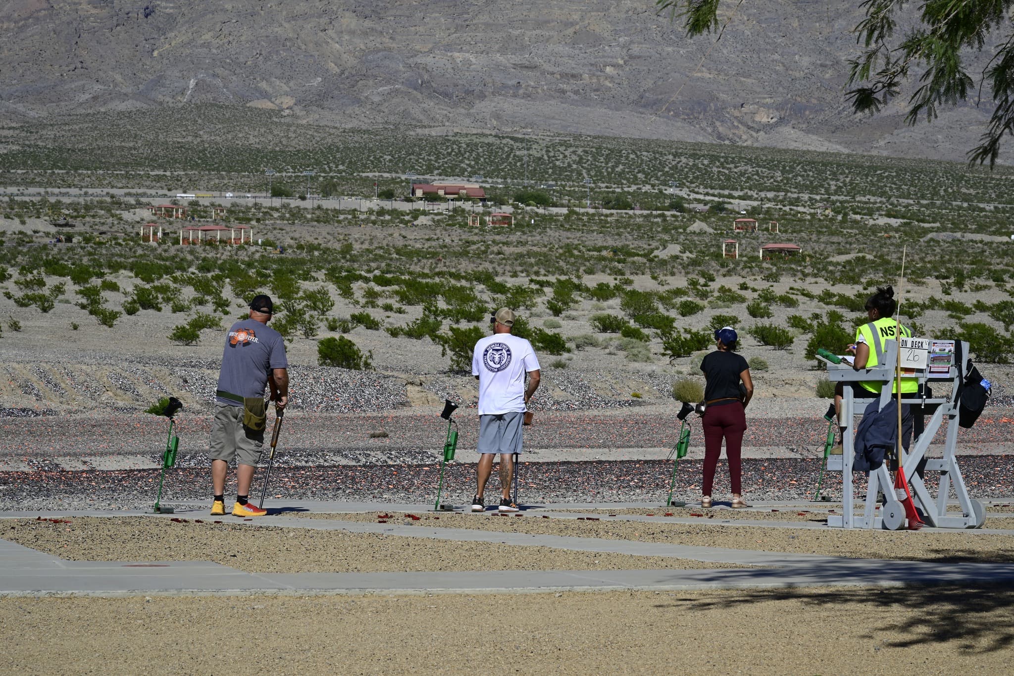 Shooters on the trap line at Clark County Shooting Complex with desert mountains